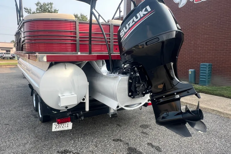 Slide: The Image of 2020 Lexington 521 pontoon boat with Suzuki outboard motor, parked on a trailer. - 3
