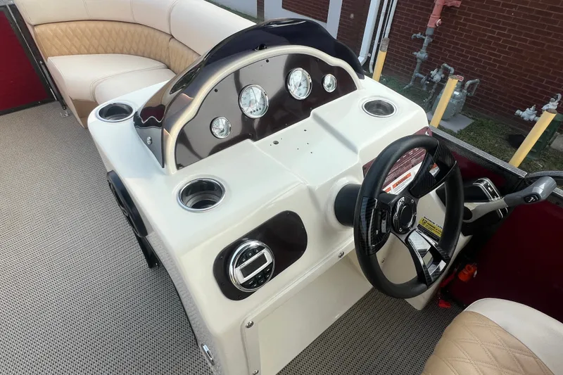 Slide: The Image of 2020 Lexington 521 boat dashboard with steering wheel and beige seating. - 24