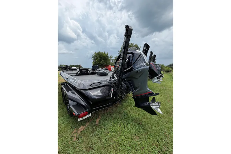 Slide: The Image of 2025 Skeeter FXR21 PRO boat on grass under cloudy sky. - 9