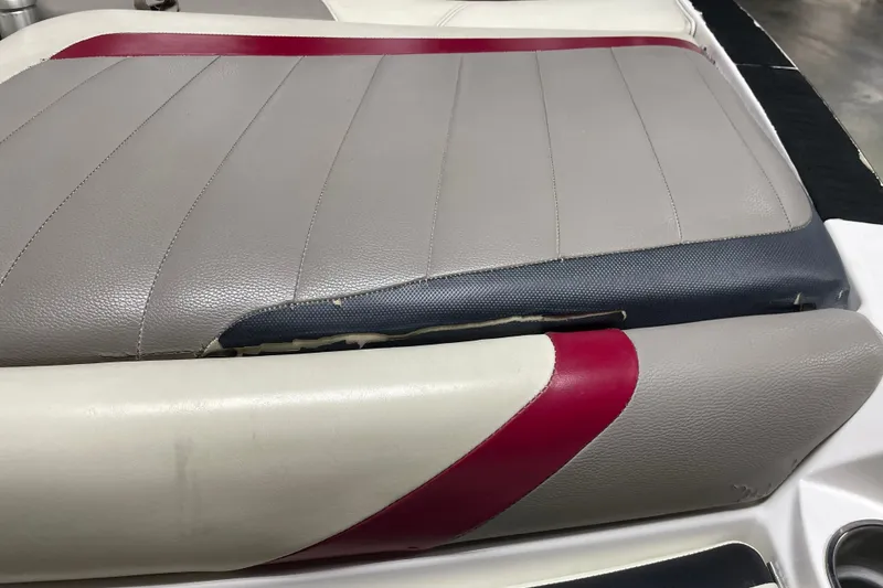 Slide: The Image of 2013 Malibu Wakesetter 20 MXZ boat seat with gray, red, and white upholstery showing wear. - 19