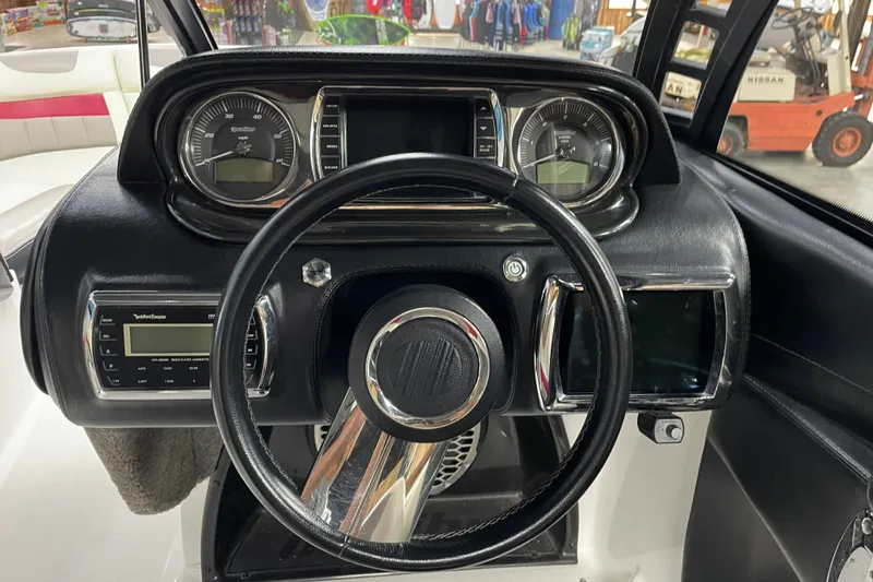 Slide: The Image of Dashboard of a 2013 Malibu Wakesetter 20 MXZ boat with steering wheel and gauges. - 13