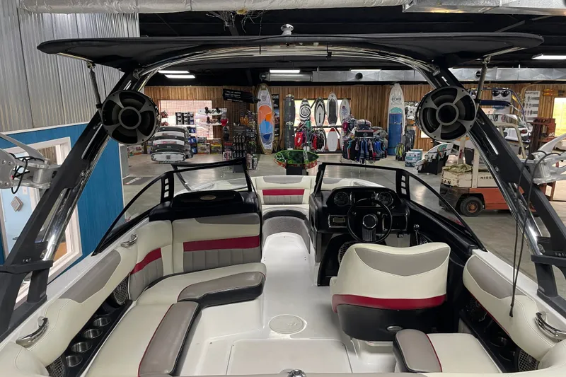 Slide: The Image of 2013 Malibu Wakesetter 20 MXZ interior with seating and speakers in a showroom. - 8