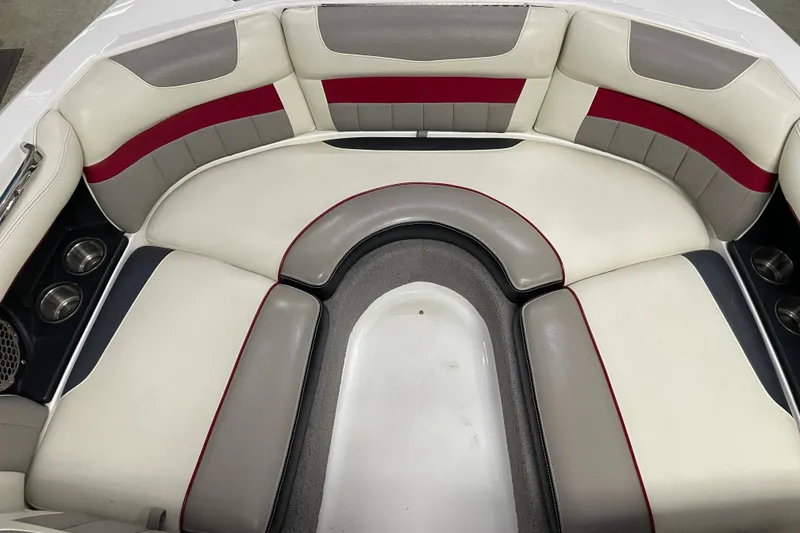 Slide: The Image of Interior seating of a 2013 Malibu Wakesetter 20 MXZ boat, featuring white and red upholstery. - 11