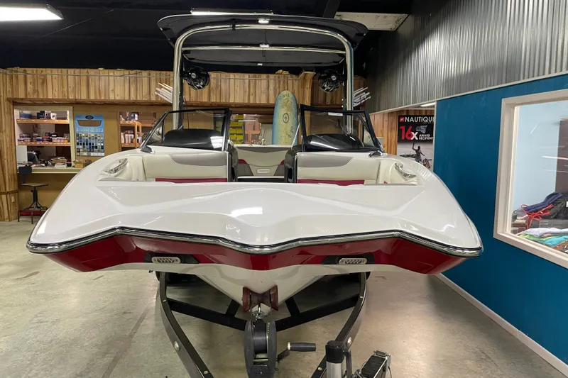 Slide: The Image of 2013 Malibu Wakesetter 20 MXZ boat in showroom, showcasing sleek design and modern features. - 5