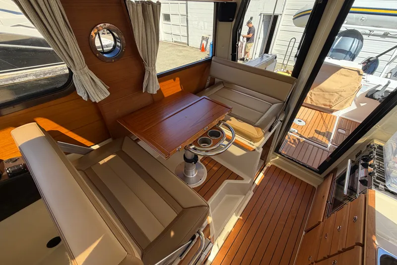 Slide: The Image of Interior of 2022 Ranger Tugs R-27 boat with wood accents and seating area. - 10