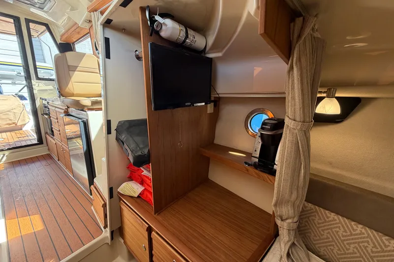 Slide: The Image of Interior of 2022 Ranger Tugs R-27 boat with kitchenette, seating, and storage. - 18