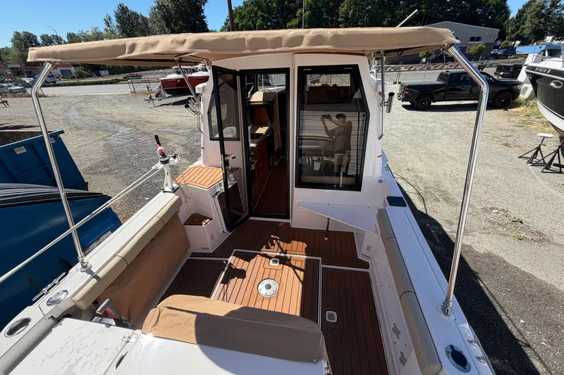 Slide: The Image of 2022 Ranger Tugs R-27 boat with teak deck and canopy, docked outdoors. - 7
