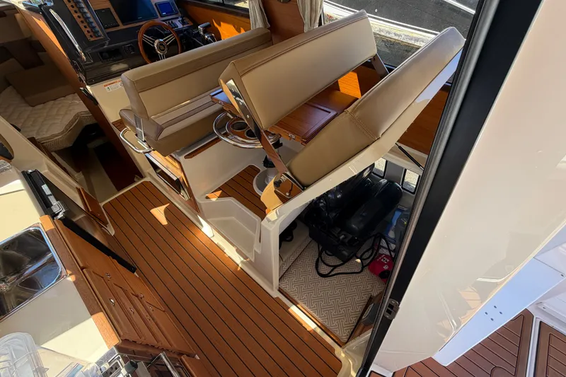 Slide: The Image of Interior of 2022 Ranger Tugs R-27 boat with wood flooring and seating area. - 9