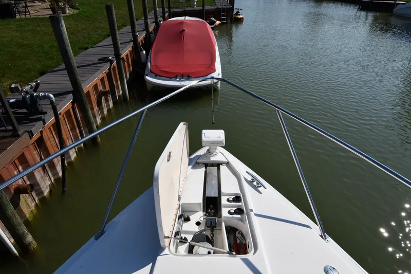 Slide: The Image of Bow view of a 2006 Formula 40 Performance Cruiser docked near a red-covered boat. - 7
