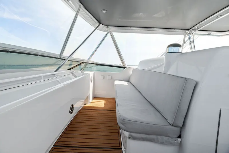 Slide: The Image of Interior view of 1999 Hatteras 60 Convertible yacht with cushioned seating and wooden flooring. - 34