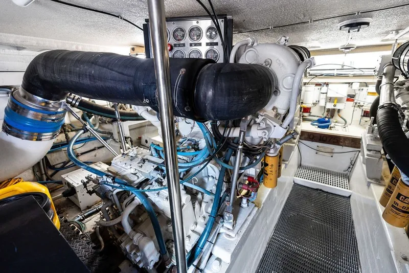 Slide: The Image of Engine room of a 1999 Hatteras 60 Convertible yacht, showcasing machinery and components. - 61