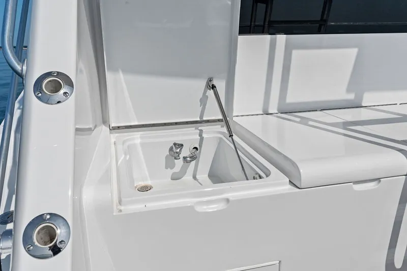 Slide: The Image of Outdoor sink on 1999 Hatteras 60 Convertible yacht deck, featuring sleek white design. - 20