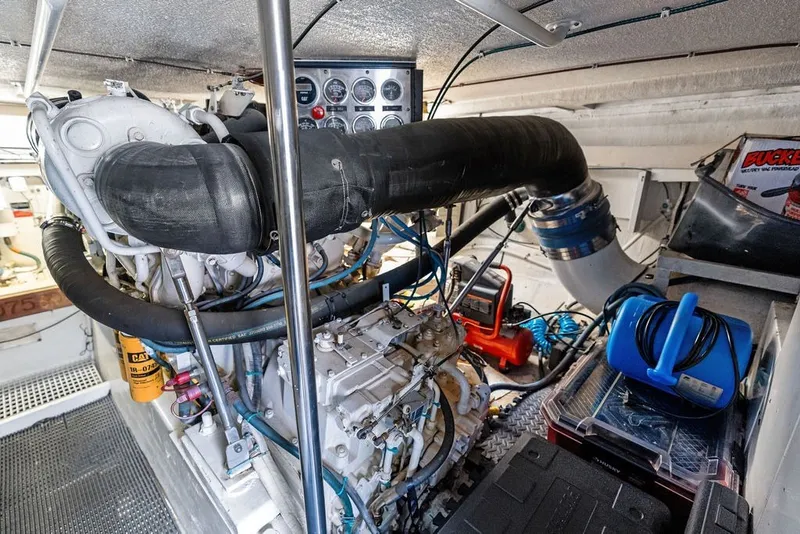 Slide: The Image of Engine room of a 1999 Hatteras 60 Convertible yacht, showcasing machinery and equipment. - 60