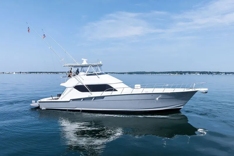The Image of 1999 Hatteras 60 Convertible yacht cruising on calm blue waters. - 0