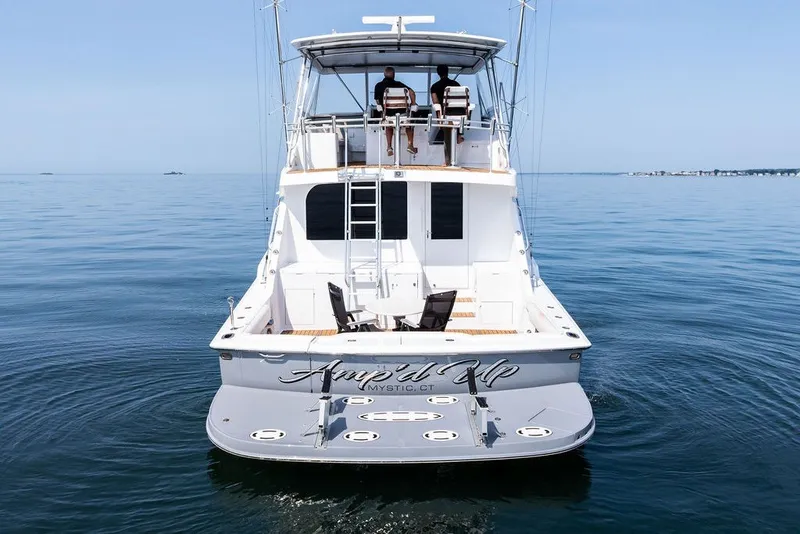 Slide: The Image of 1999 Hatteras 60 Convertible yacht on calm water, rear view. - 7