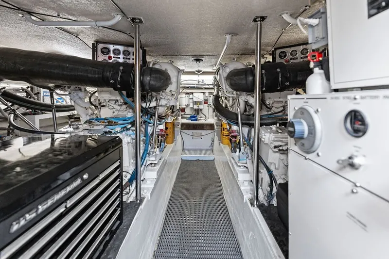 Slide: The Image of Engine room of 1999 Hatteras 60 Convertible yacht, showcasing dual engines and control systems. - 58