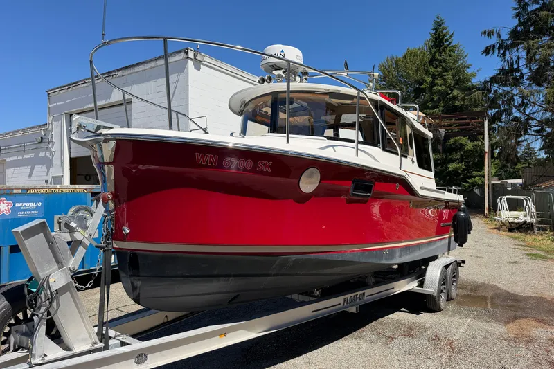 Slide: The Image of 2017 Ranger Tugs R-23 boat in vibrant red on a trailer, parked outdoors. - 6
