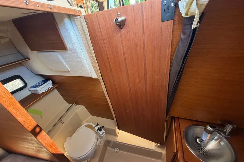 Slide: The Image of 2017 Ranger Tugs R-23 boat interior with compact bathroom and wooden cabinetry. - 18