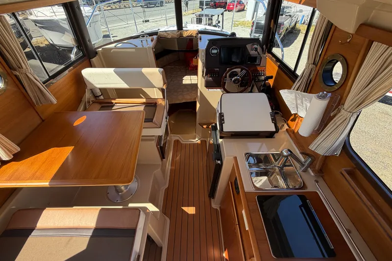 Slide: The Image of Interior of 2017 Ranger Tugs R-23 boat with wood finishes and compact kitchen area. - 11