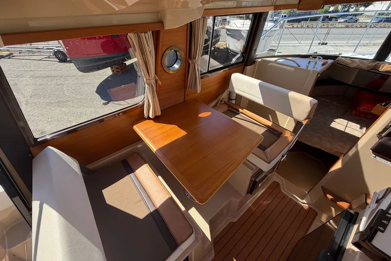 Slide: The Image of Interior of 2017 Ranger Tugs R-23 boat with wooden table and seating area. - 12