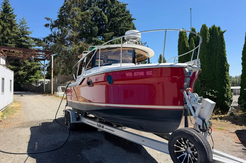 Slide: The Image of 2017 Ranger Tugs R-23 boat on trailer, vibrant red hull, parked outdoors. - 9