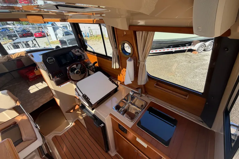 Slide: The Image of Interior of 2017 Ranger Tugs R-23 boat with helm, kitchenette, and seating area. - 13