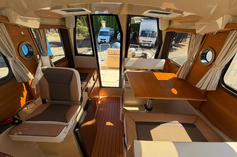 Slide: The Image of Interior of 2017 Ranger Tugs R-23 boat with seating and wooden table. - 16