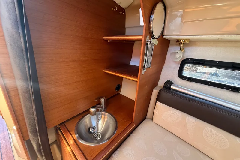 Slide: The Image of 2017 Ranger Tugs R-23 interior with wooden shelves, sink, and window. - 19