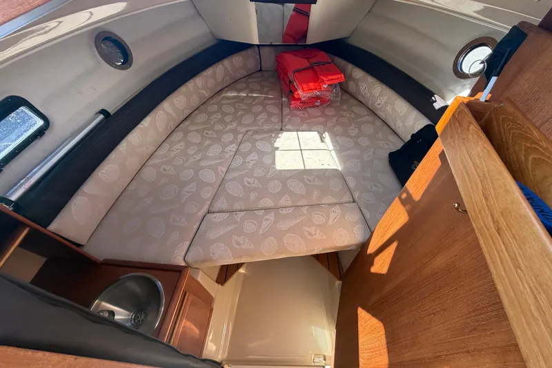 Slide: The Image of 2017 Ranger Tugs R-23 cabin interior with cushioned seating and life jackets. - 17