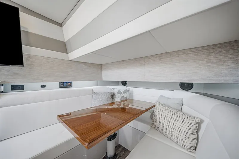 Slide: The Image of Luxurious interior of 2022 Cruisers Yachts 42 GLS I/O with elegant seating and wooden table. - 34