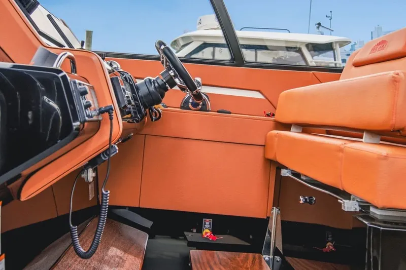 Slide: The Image of Interior view of 2022 Cruisers Yachts 42 GLS I/O with orange seating and steering wheel. - 63