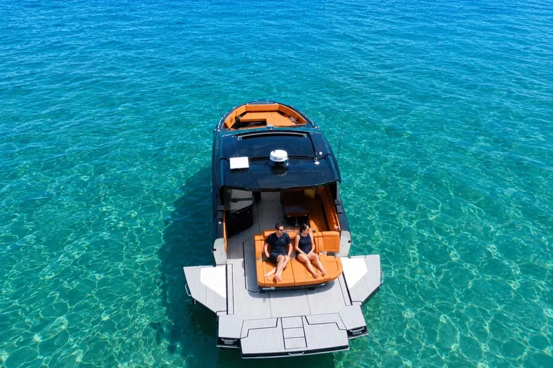 Slide: The Image of 2022 Cruisers Yachts 42 GLS I/O on clear turquoise water, featuring a spacious deck. - 9