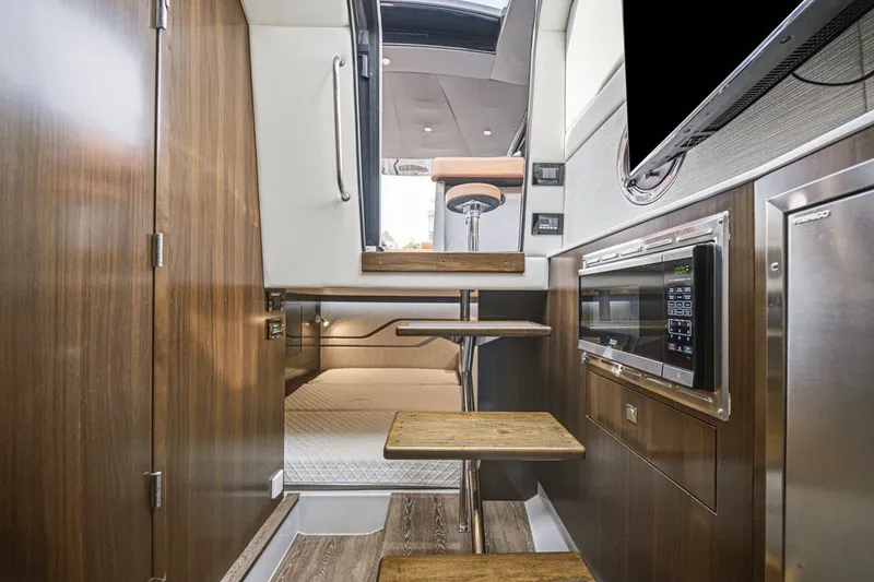 Slide: The Image of Interior of 2022 Cruisers Yachts 42 GLS I/O with modern kitchen and wooden stairs. - 24