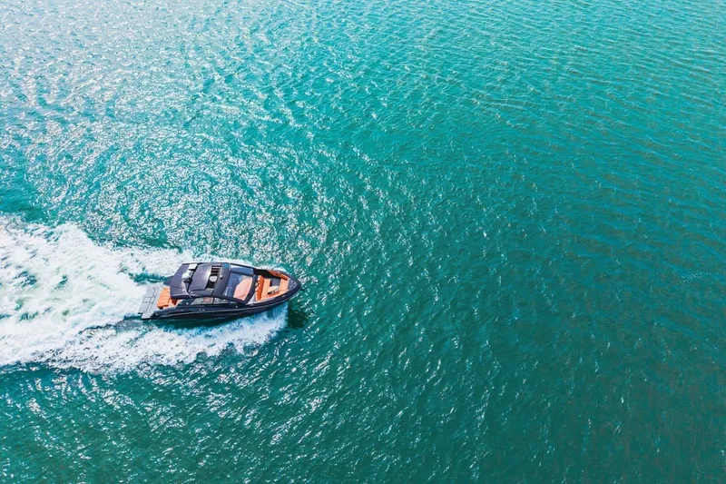 Slide: The Image of Aerial view of 2022 Cruisers Yachts 42 GLS I/O cruising on vibrant blue water. - 18