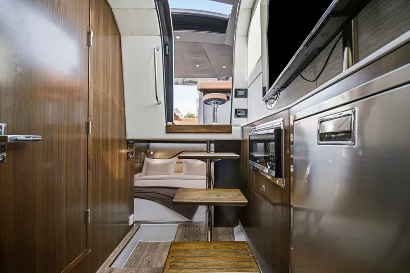 Slide: The Image of Interior of 2022 Cruisers Yachts 42 GLS I/O, featuring modern kitchen and wooden steps. - 36