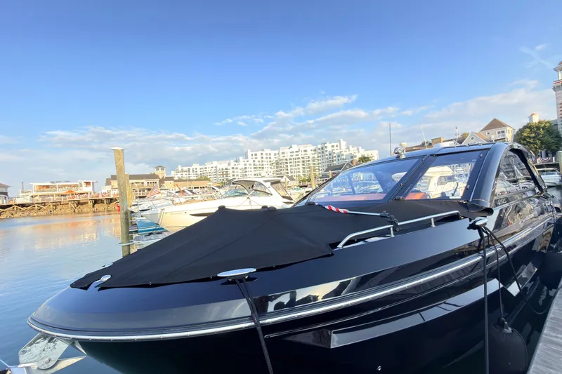 Slide: The Image of 2022 Cruisers Yachts 42 GLS I/O docked at a marina with cityscape background. - 8