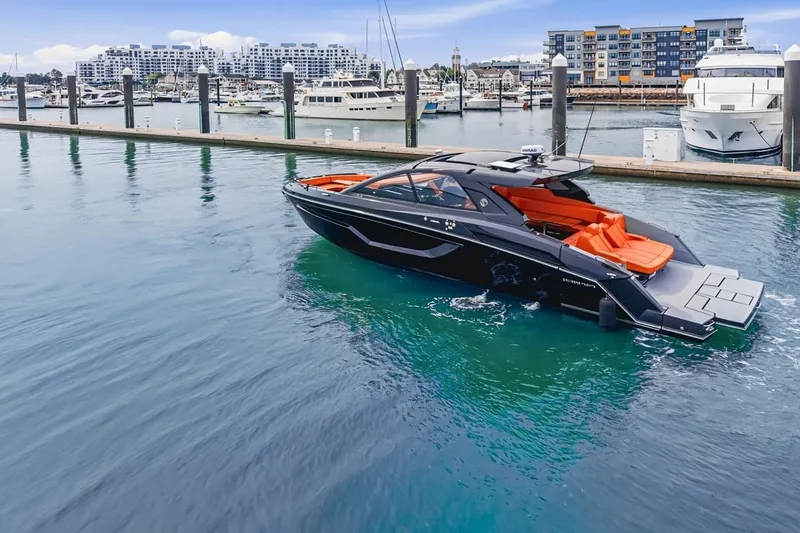 Slide: The Image of 2022 Cruisers Yachts 42 GLS I/O in marina, sleek design, vibrant orange seating. - 3