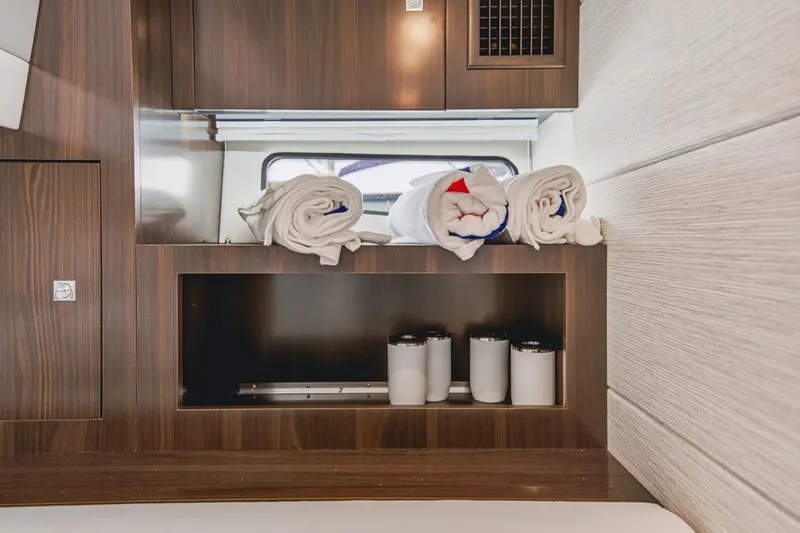 Slide: The Image of Luxurious interior of 2022 Cruisers Yachts 42 GLS I/O with neatly arranged towels and cups. - 59