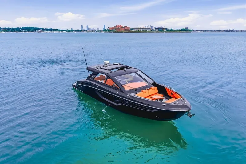 Slide: The Image of 2022 Cruisers Yachts 42 GLS I/O on calm blue water, city skyline in background. - 4