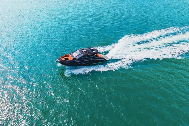 Slide: The Image of 2022 Cruisers Yachts 42 GLS I/O cruising on clear blue water. - 10