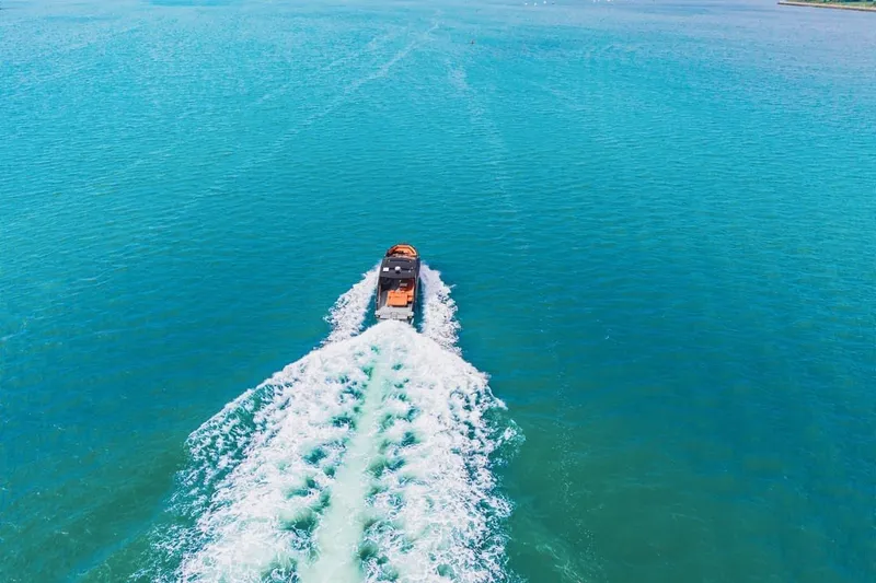 Slide: The Image of 2022 Cruisers Yachts 42 GLS I/O cruising on clear blue water, aerial view. - 17