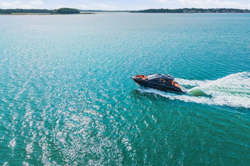 Slide: The Image of 2022 Cruisers Yachts 42 GLS I/O cruising on clear blue water. - 11
