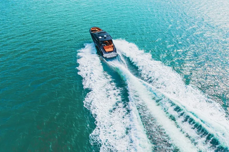 Slide: The Image of Aerial view of 2022 Cruisers Yachts 42 GLS I/O speeding on turquoise water. - 14