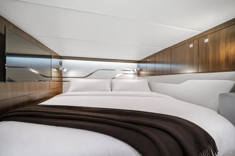 Slide: The Image of Luxurious cabin interior of 2022 Cruisers Yachts 42 GLS I/O with elegant bedding and wood accents. - 25