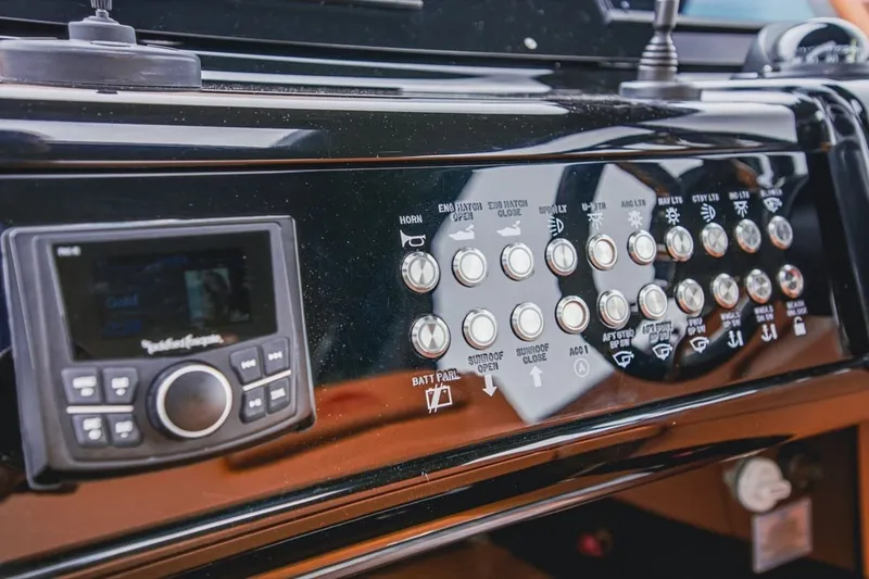 Slide: The Image of Control panel of 2022 Cruisers Yachts 42 GLS I/O with various switches and a display. - 73
