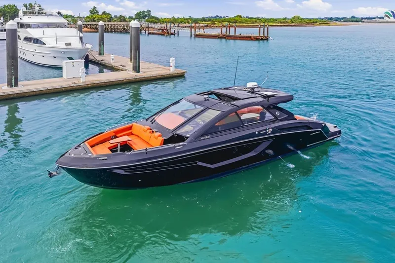 The Image of 2022 Cruisers Yachts 42 GLS I/O in marina, sleek design, vibrant orange seating. - 1