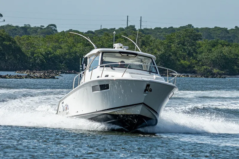 Slide: The Image of 2020 Pursuit OS 355 Offshore boat cruising on a scenic waterway. - 24