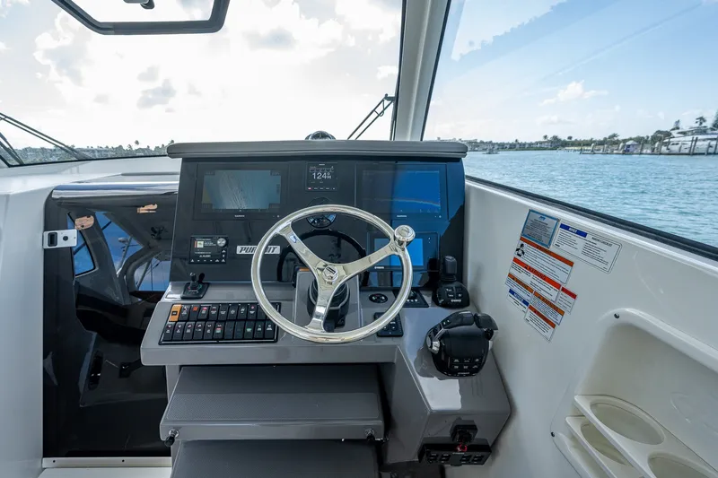 Slide: The Image of 2020 Pursuit OS 355 Offshore helm with modern navigation equipment and ocean view. - 38