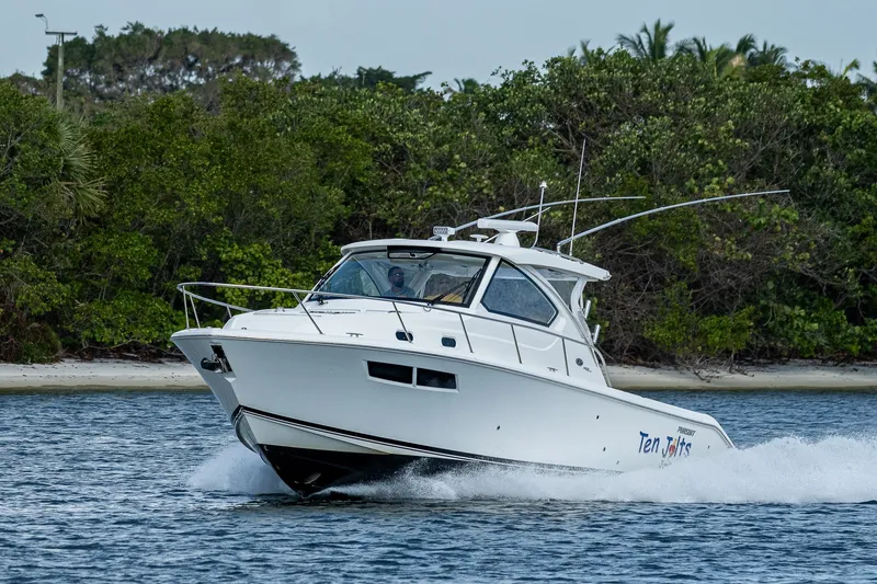 Slide: The Image of 2020 Pursuit OS 355 Offshore boat cruising near lush shoreline. - 17