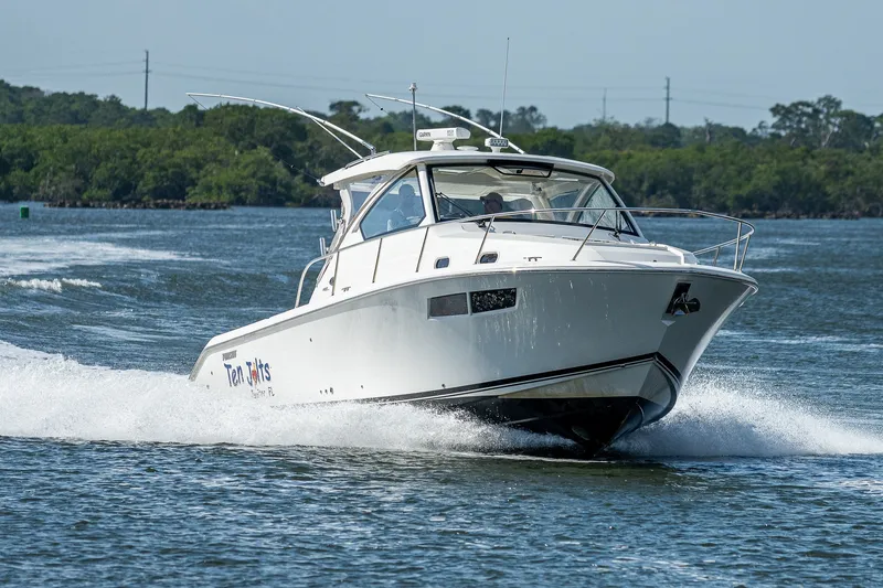 Slide: The Image of 2020 Pursuit OS 355 Offshore boat cruising on a scenic waterway. - 25